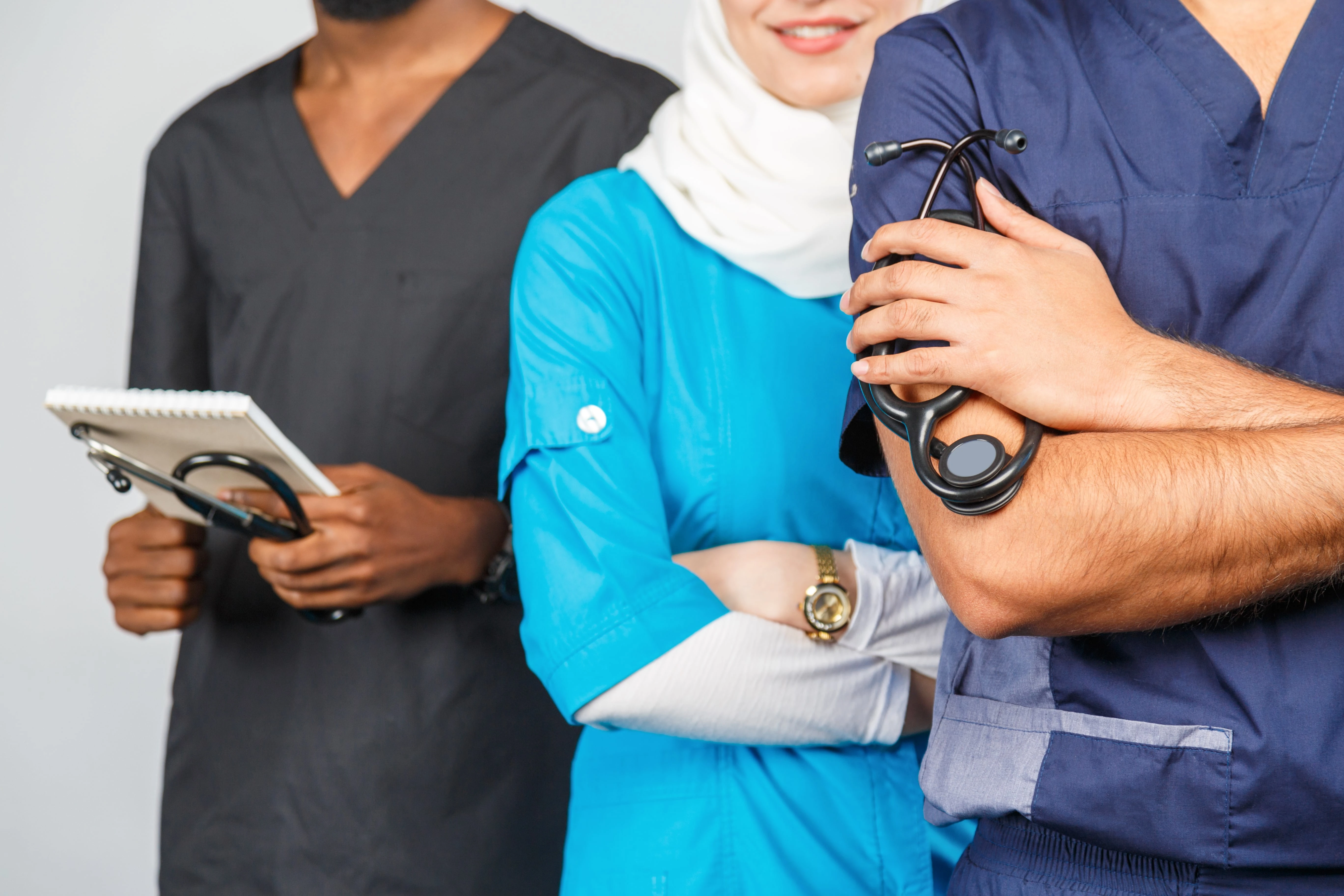3 nhs workers in different coloured scrubs